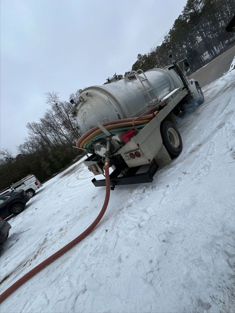 Jay's Pump Service truck pumping a septic tank in winter in Central Arkansas